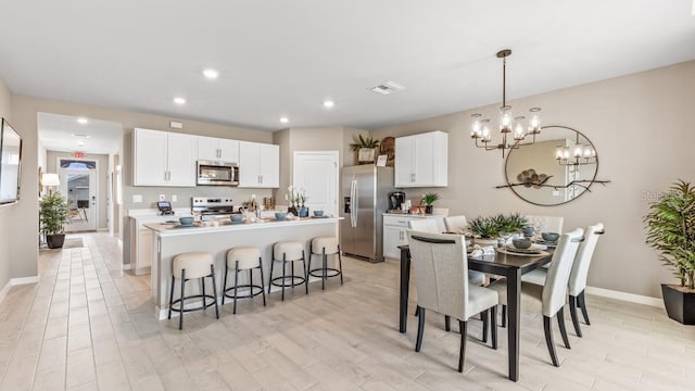 9710 Sand Dune Ln, Punta Gorda, FL 33950 - dining area with a chandelier, light wood-style floors, baseboards, and recessed lighting