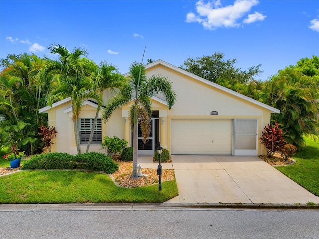 1812 Birmingham Blvd, Punta Gorda, FL 33980 - view of front of house with stucco siding, a front yard, an attached garage, and driveway
