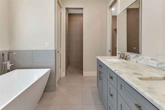 5451 Prime Ter, North Port, FL 34286 - bathroom with a soaking tub, double vanity, tile patterned floors, tiled shower, and tile walls