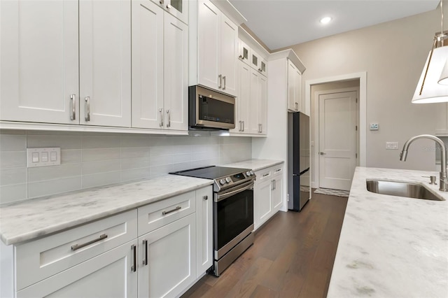 5451 Prime Ter, North Port, FL 34286 - kitchen with a sink, appliances with stainless steel finishes, white cabinets, glass insert cabinets, and dark wood-style flooring