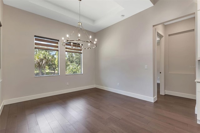 5451 Prime Ter, North Port, FL 34286 - unfurnished room with a chandelier, dark wood finished floors, a tray ceiling, and baseboards