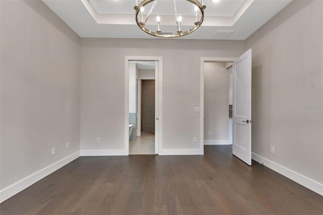 5451 Prime Ter, North Port, FL 34286 - empty room with a raised ceiling, a chandelier, dark wood-style flooring, and baseboards