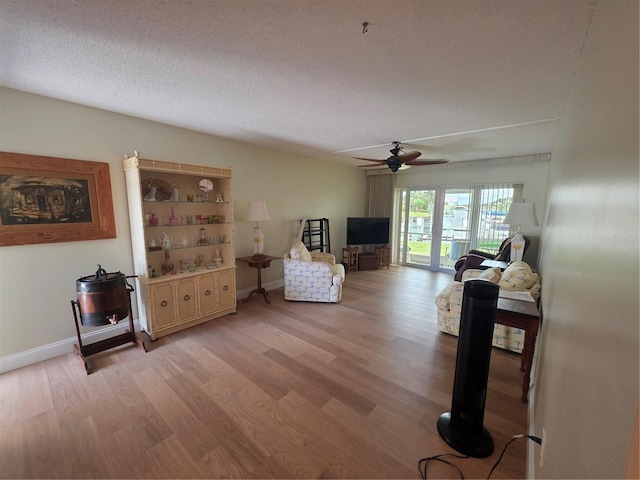 311 Garvin St Unit 405B, Punta Gorda, FL 33950 - living room featuring light wood-style floors, a ceiling fan, a textured ceiling, and baseboards