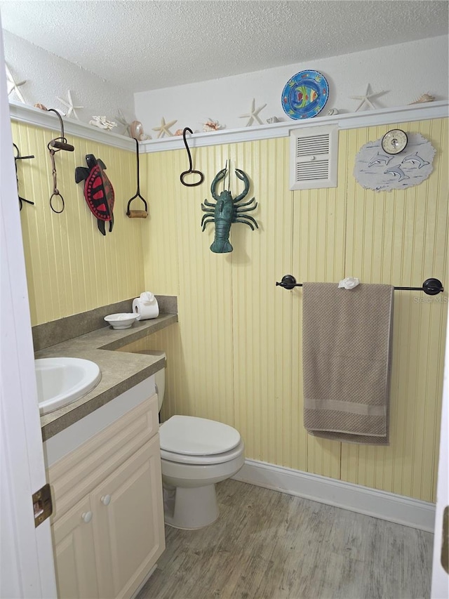 311 Garvin St Unit 405B, Punta Gorda, FL 33950 - bathroom featuring vanity, wood finished floors, toilet, a textured ceiling, and wood walls
