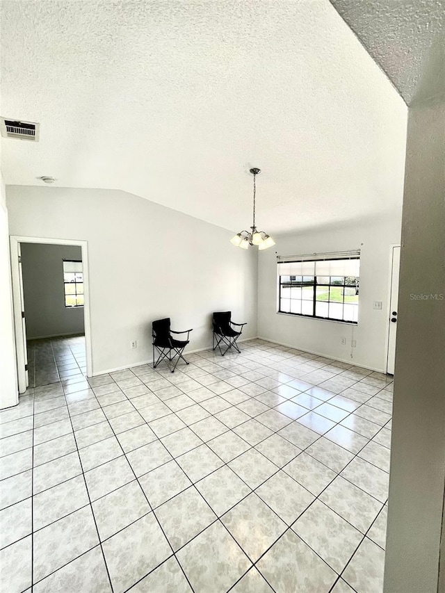 13100 S Mccall Rd Unit 125, Port Charlotte, FL 33981 - unfurnished living room featuring a textured ceiling, light tile patterned flooring, a chandelier, and vaulted ceiling