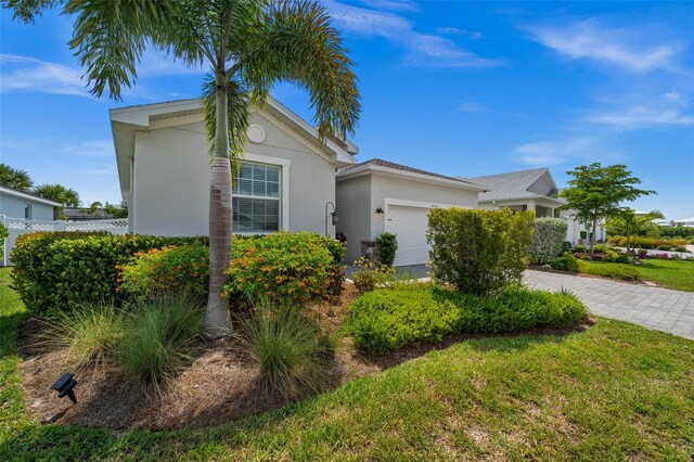 16176 Lotus Way, Punta Gorda, FL 33982 - view of front of property featuring an attached garage, stucco siding, driveway, and a front yard