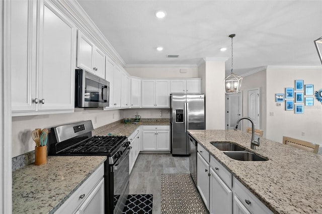 16176 Lotus Way, Punta Gorda, FL 33982 - kitchen with stainless steel appliances, a sink, ornamental molding, white cabinets, and light stone countertops