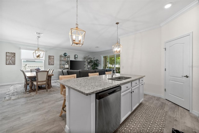 16176 Lotus Way, Punta Gorda, FL 33982 - kitchen featuring dishwasher, a sink, an island with sink, light stone countertops, and hanging light fixtures