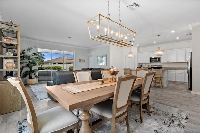 16176 Lotus Way, Punta Gorda, FL 33982 - dining space featuring crown molding, a chandelier, and recessed lighting