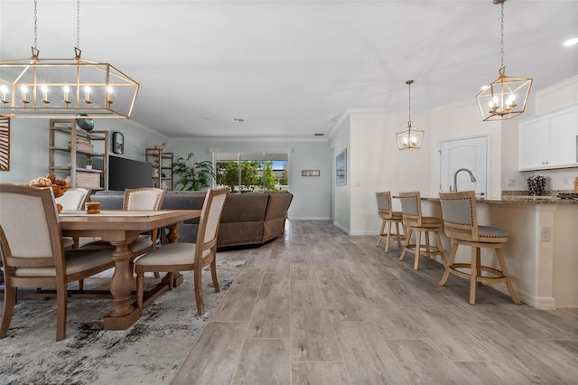 16176 Lotus Way, Punta Gorda, FL 33982 - dining area featuring a chandelier, ornamental molding, light wood finished floors, and baseboards