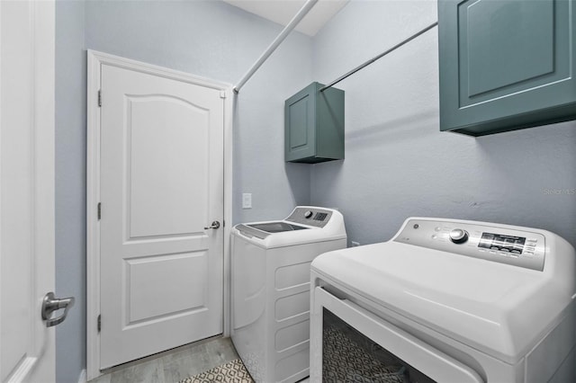 16176 Lotus Way, Punta Gorda, FL 33982 - laundry room with washer and clothes dryer, cabinet space, and light wood-type flooring
