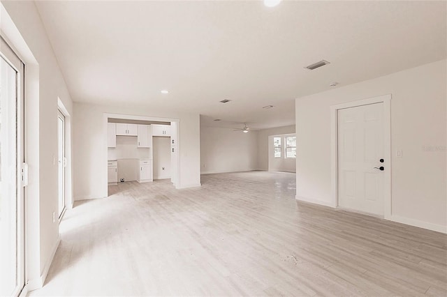 37 Oakland Hills Ct, Rotonda West, FL 33947 - unfurnished living room with light wood-type flooring, baseboards, and ceiling fan