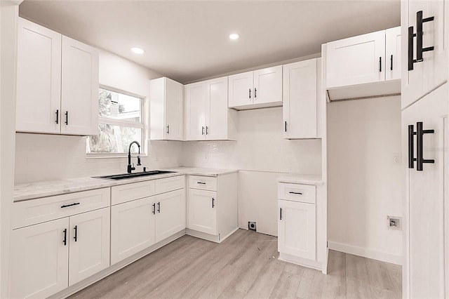 37 Oakland Hills Ct, Rotonda West, FL 33947 - kitchen with a sink, tasteful backsplash, light wood-type flooring, white cabinetry, and recessed lighting