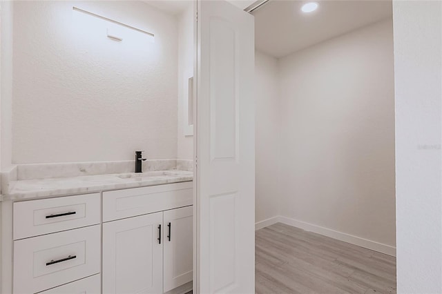 37 Oakland Hills Ct, Rotonda West, FL 33947 - bathroom with wood finished floors, vanity, baseboards, and recessed lighting