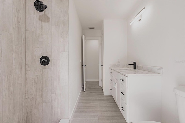 37 Oakland Hills Ct, Rotonda West, FL 33947 - full bathroom featuring a tile shower, wood finished floors, toilet, and vanity