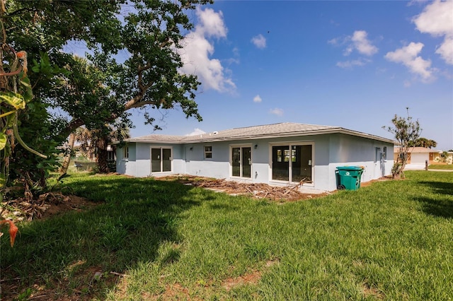 37 Oakland Hills Ct, Rotonda West, FL 33947 - rear view of property with a lawn and stucco siding