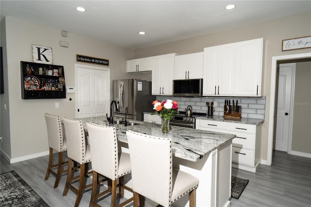 6794 Loffreda Ave, North Port, FL 34291 - kitchen with appliances with stainless steel finishes, white cabinets, wood finished floors, backsplash, and recessed lighting