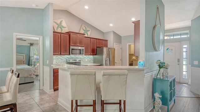 237 Strasburg Dr, Port Charlotte, FL 33954 - kitchen with stainless steel appliances, vaulted ceiling, backsplash, a kitchen breakfast bar, and a peninsula