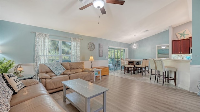 237 Strasburg Dr, Port Charlotte, FL 33954 - living room with lofted ceiling, a ceiling fan, light wood-type flooring, and a chandelier