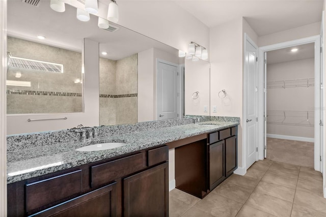 42346 Waterfront Way, Punta Gorda, FL 33982 - bathroom featuring double vanity, a walk in closet, tile patterned floors, tiled shower, and recessed lighting