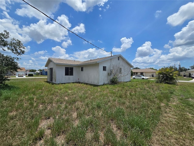 4424 Baroda Ave, North Port, FL 34287 - back of house featuring stucco siding and a lawn