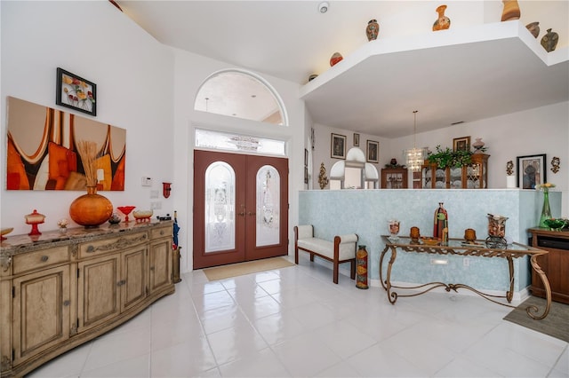 17400 White Water Ct, Punta Gorda, FL 33982 - entryway with light tile patterned floors, french doors, a towering ceiling, and a chandelier