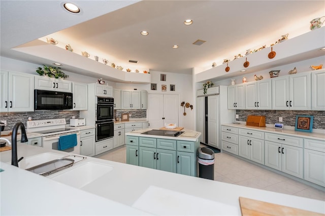 17400 White Water Ct, Punta Gorda, FL 33982 - kitchen with black appliances, decorative backsplash, light tile patterned floors, light countertops, and recessed lighting