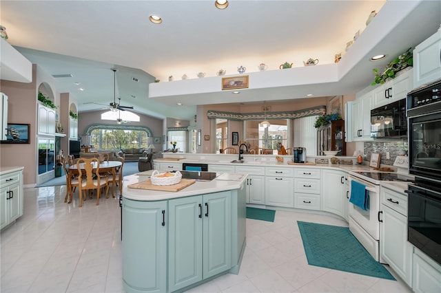 17400 White Water Ct, Punta Gorda, FL 33982 - kitchen featuring black appliances, a peninsula, light countertops, open floor plan, and a center island