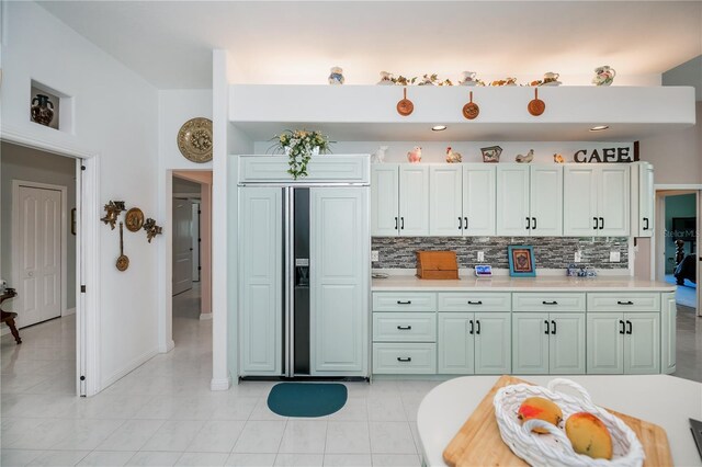 17400 White Water Ct, Punta Gorda, FL 33982 - kitchen with paneled refrigerator, tasteful backsplash, light countertops, and light tile patterned floors