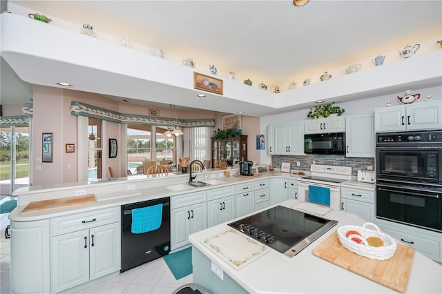 17400 White Water Ct, Punta Gorda, FL 33982 - kitchen with black appliances, a peninsula, light countertops, tasteful backsplash, and light tile patterned floors
