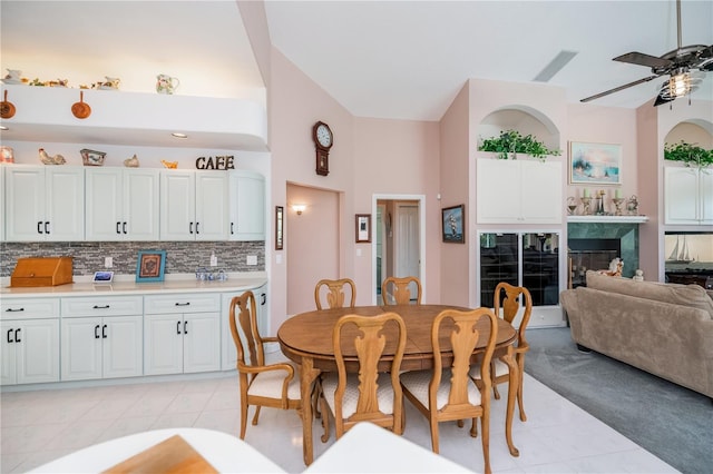 17400 White Water Ct, Punta Gorda, FL 33982 - dining area with light tile patterned floors, ceiling fan, a high end fireplace, and high vaulted ceiling