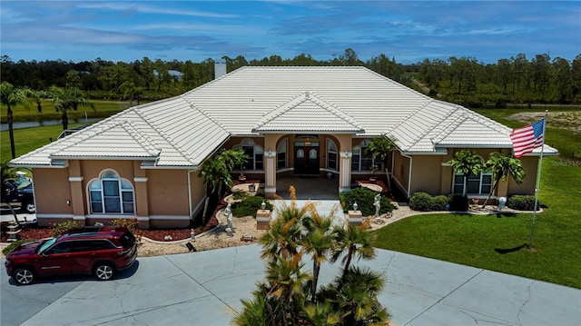 17400 White Water Ct, Punta Gorda, FL 33982 - view of front of house featuring a tiled roof, stucco siding, a front yard, and driveway