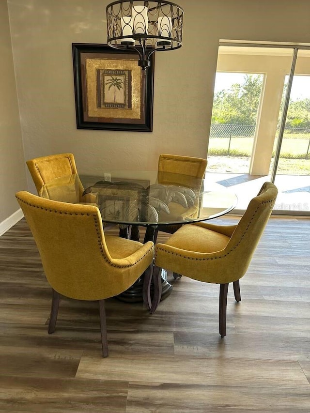 26129 Madras Ct, Punta Gorda, FL 33983 - dining area featuring a chandelier, wood finished floors, and baseboards