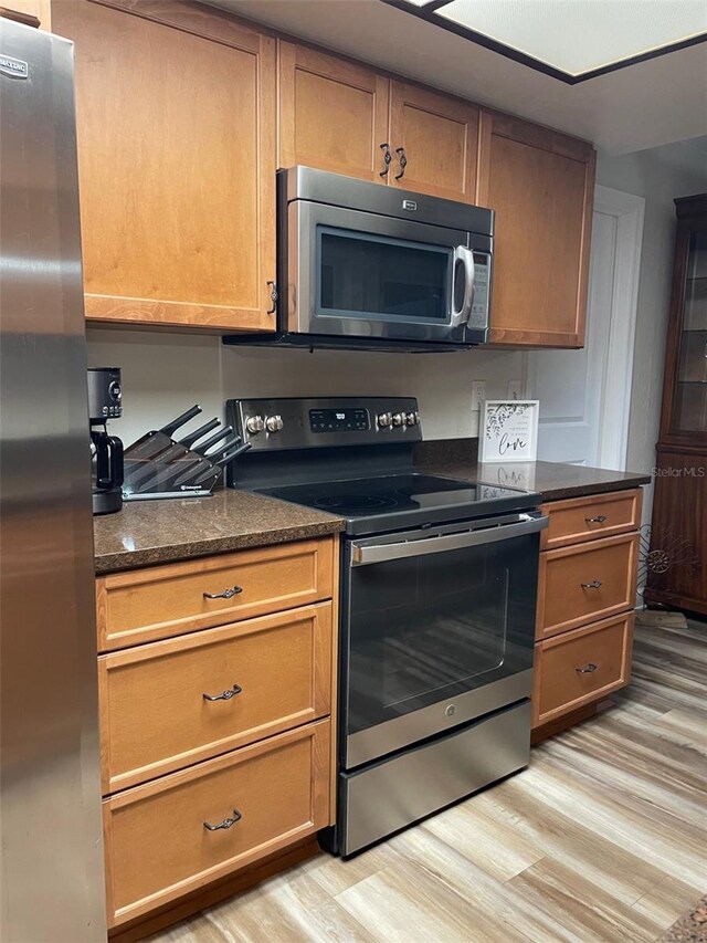 26129 Madras Ct, Punta Gorda, FL 33983 - kitchen featuring appliances with stainless steel finishes, light wood-style flooring, and brown cabinets