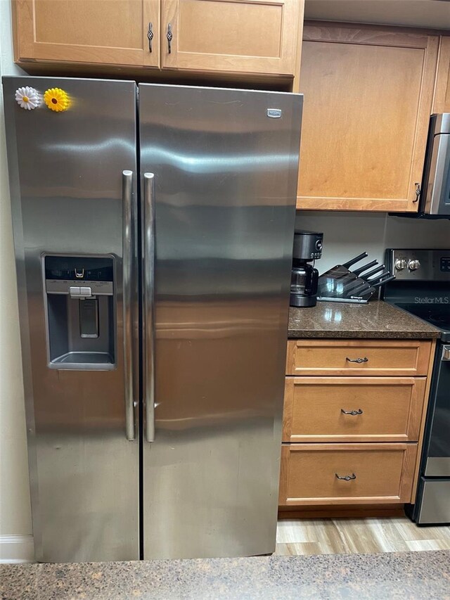 26129 Madras Ct, Punta Gorda, FL 33983 - kitchen featuring appliances with stainless steel finishes, light wood-type flooring, and dark stone counters