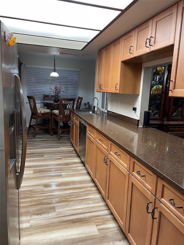 26129 Madras Ct, Punta Gorda, FL 33983 - kitchen featuring stainless steel appliances, a sink, light wood-type flooring, dark stone countertops, and pendant lighting
