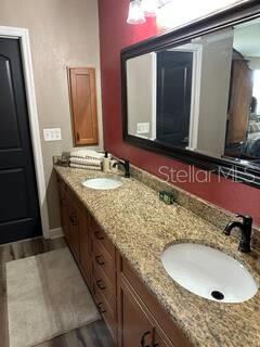 26129 Madras Ct, Punta Gorda, FL 33983 - full bath with wood finished floors, double vanity, and baseboards