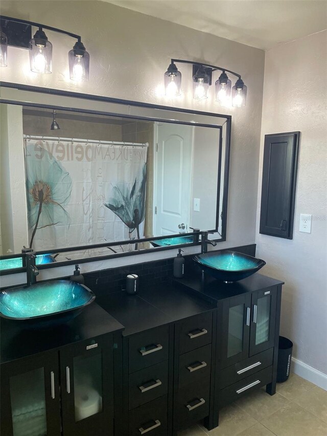 26129 Madras Ct, Punta Gorda, FL 33983 - full bathroom featuring double vanity, a shower with curtain, tile patterned flooring, baseboards, and a textured wall