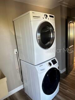 26129 Madras Ct, Punta Gorda, FL 33983 - laundry room with stacked washer and clothes dryer, baseboards, and dark wood-type flooring