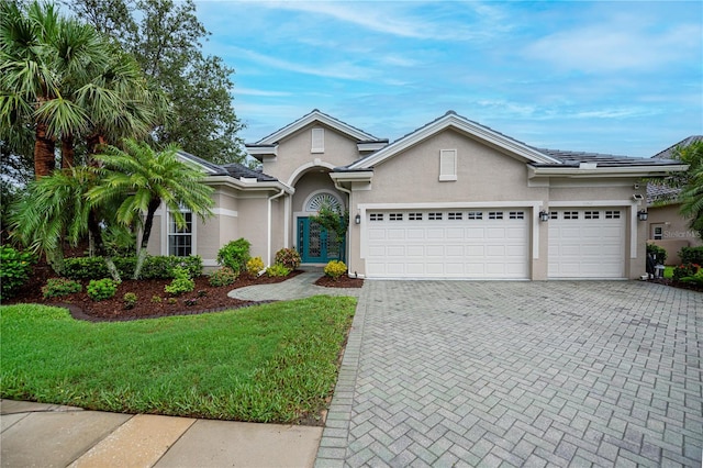 1062 Eagles Flight Way, North Port, FL 34287 - view of front of property with stucco siding, a garage, decorative driveway, and a front lawn
