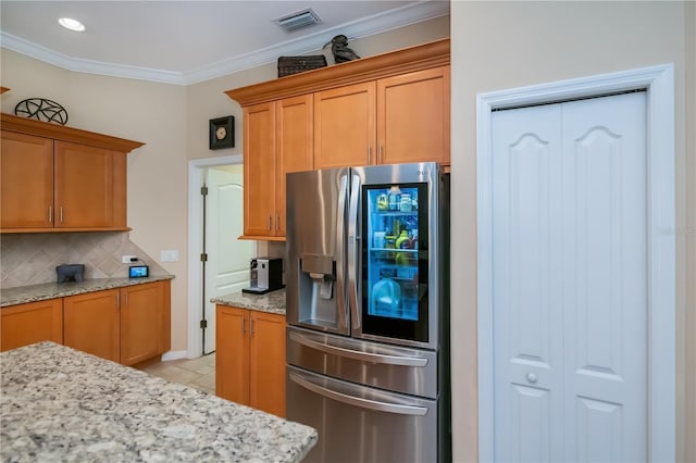 1062 Eagles Flight Way, North Port, FL 34287 - kitchen with stainless steel fridge, tasteful backsplash, light stone counters, light tile patterned floors, and ornamental molding