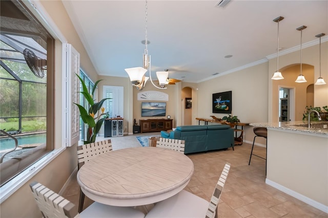 1062 Eagles Flight Way, North Port, FL 34287 - dining room featuring arched walkways, baseboards, crown molding, and a chandelier