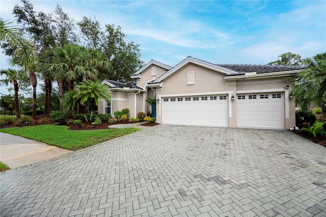 1062 Eagles Flight Way, North Port, FL 34287 - view of front of house with stucco siding, decorative driveway, and an attached garage