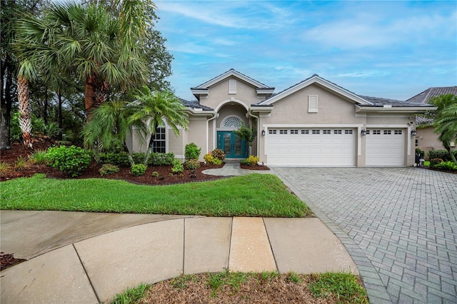 1062 Eagles Flight Way, North Port, FL 34287 - view of front facade with stucco siding, a garage, decorative driveway, and a front lawn