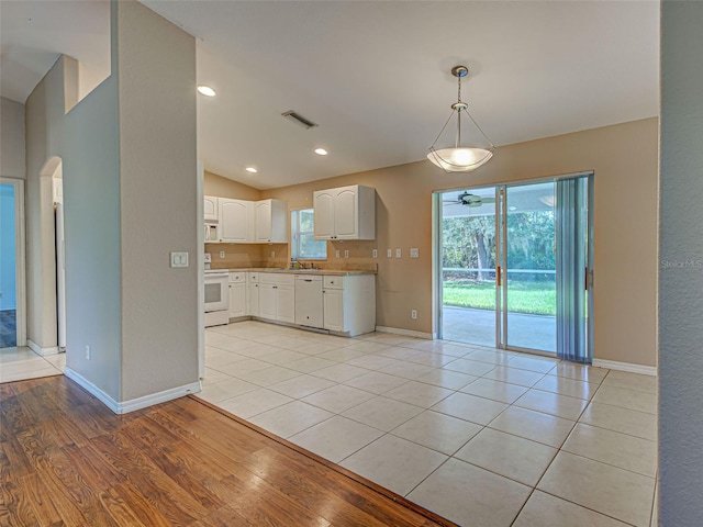 4609 Jaslo Ave, North Port, FL 34286 - kitchen featuring white appliances, arched walkways, baseboards, white cabinetry, and light countertops