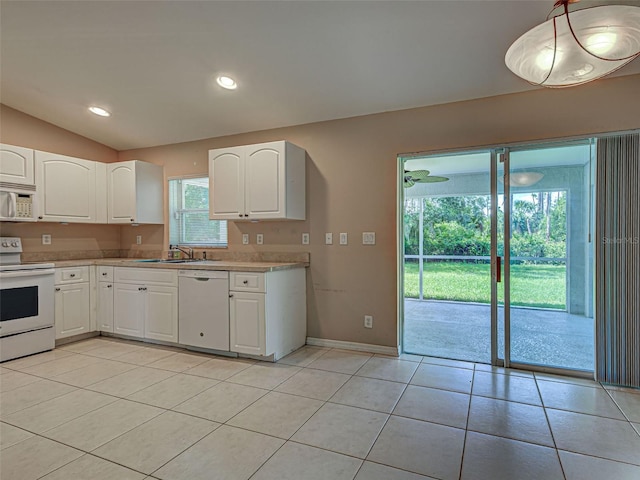 4609 Jaslo Ave, North Port, FL 34286 - kitchen with white appliances, light countertops, white cabinets, baseboards, and vaulted ceiling