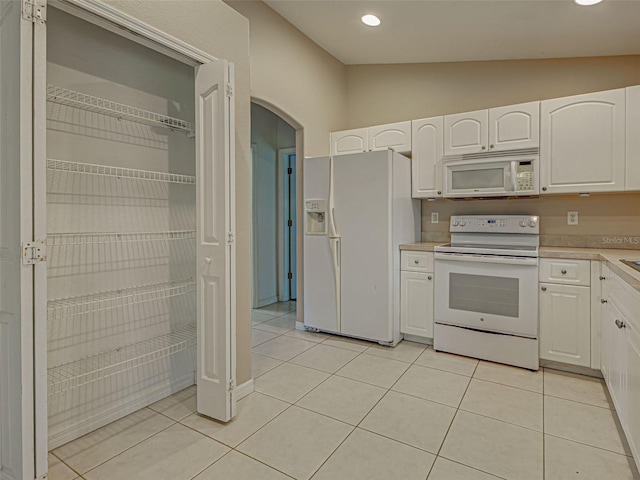 4609 Jaslo Ave, North Port, FL 34286 - kitchen featuring white appliances, white cabinets, light countertops, arched walkways, and lofted ceiling