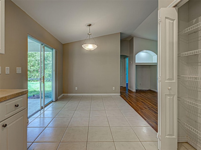 4609 Jaslo Ave, North Port, FL 34286 - unfurnished dining area with vaulted ceiling, baseboards, and light tile patterned flooring