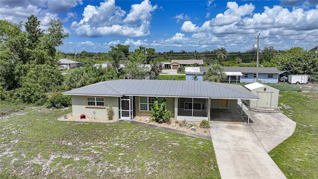 3171 Highlands Rd, Punta Gorda, FL 33983 - ranch-style house with a sunroom, a front lawn, concrete driveway, a carport, and a metal roof