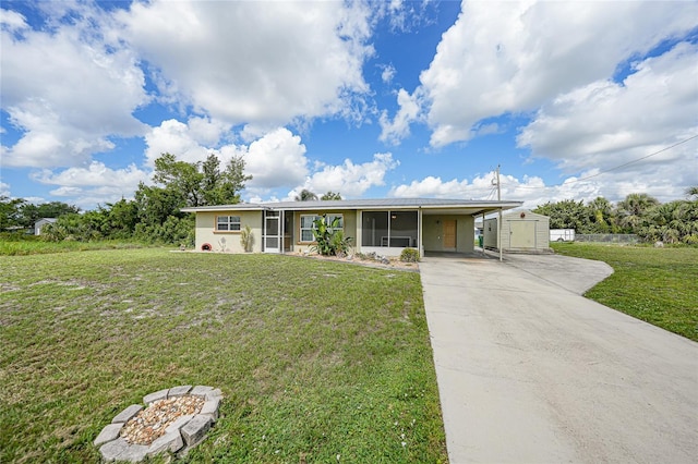 3171 Highlands Rd, Punta Gorda, FL 33983 - ranch-style home with a sunroom, a storage unit, concrete driveway, a front yard, and an attached carport